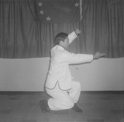 Posture 8 : main gauche posée au-dessus de la tête, la paume droite balayant la taille