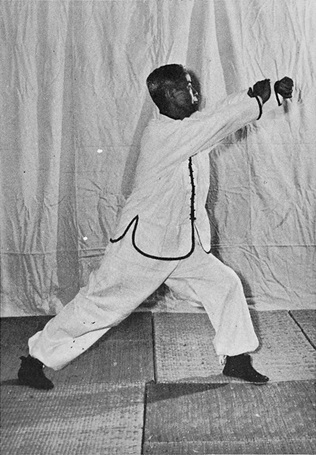 Posture 8 : ascension à gauche, poing gauche balayant à droite contre la paume droite — photographie de l&rsquo;édition de 1972