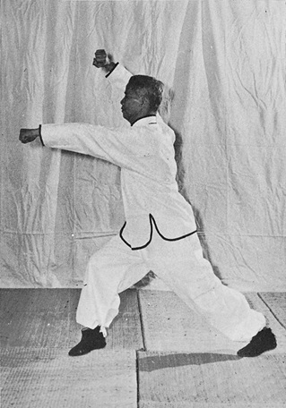Posture 20 : ascension à droite, avant-bras droit barré au-dessus de la tête, poing gauche transperçant — photographie de l&rsquo;édition de 1972