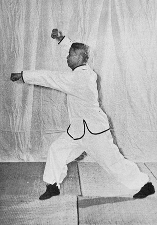 Posture 34 : retournement en ascension à droite, avant-bras droit barré au-dessus de la tête, poing gauche jailli — photographie de l&rsquo;édition de 1972