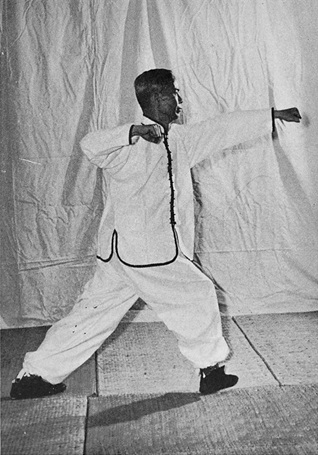 Posture 4 : ascension à droite, main droite retirée au coude, poing gauche poussé droit devant — photographie de l&rsquo;édition de 1972