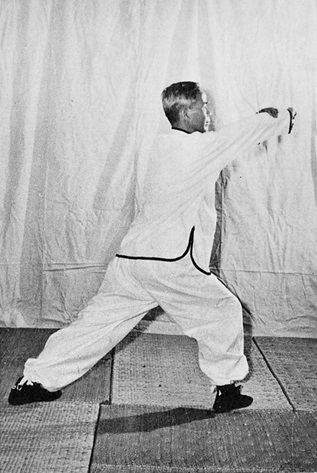 Posture 5 : poing circulaire droit balayant vers la gauche, arrêté par la paume gauche à mi-course — photographie de l&rsquo;édition de 1972