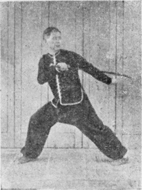 Posture 44, position de passage (planche 44a) : le pied droit ouvert vers l&rsquo;est, le sabre et la main crochue gauche légèrement écartés