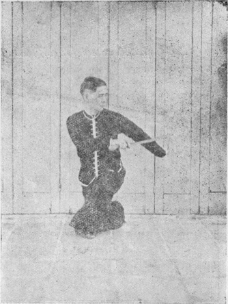Posture 46, figure finale (planche 46c) : la posture assise en torsion, le sabre descendu de l&rsquo;épaule droite à l&rsquo;épaule gauche, la main gauche soutenant le dos de la lame