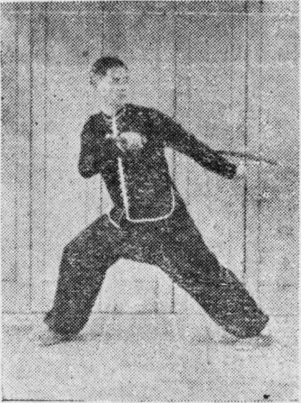 Posture 52, position de passage (planche 52a) : le pied droit ouvert vers l&rsquo;est, le sabre et la main crochue gauche légèrement écartés