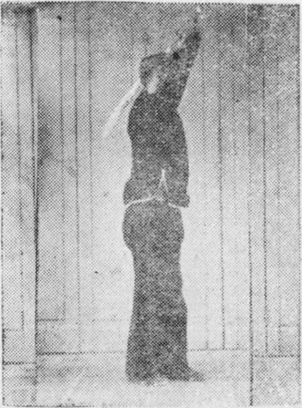 Posture 54, position de passage A (planche 54a) : le pied droit postérieur tapant le sol pour rejoindre le pied gauche, la paume gauche à l&rsquo;intérieur du poignet droit, tous deux élevés