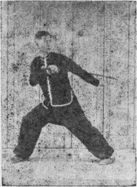 Posture 13, position de passage (planche 13a) : le pied droit ouvert vers l&rsquo;est, le sabre et la main crochue gauche légèrement écartés
