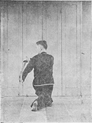 Posture 27, figure finale (planche 27b) : la posture assise en torsion, le sabre descendu de l&rsquo;épaule droite à l&rsquo;épaule gauche, la main crochue gauche soutenant le dos de la lame