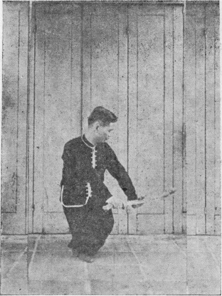 Posture 31, figure finale (planche 31c) : la posture assise en torsion, le sabre frappant en travers de haut en bas, la paume gauche sur le dos de la lame