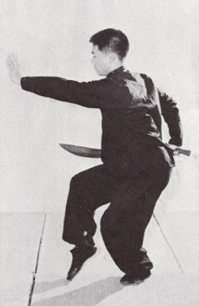 Posture 9 (planche 9) : le pas de chevaucher le tigre à droite, le sabre ressorti par l&rsquo;épaule gauche en tirant, la paume gauche poussée au-delà de la lame