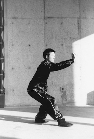 Posture 20, position de passage B (planche 20b) : la posture vide basse sur le pied droit, la main portée vers la gauche