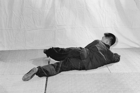 Posture 28 (planche 28) : le corps jeté au sol, les jambes croisées, le sabre posé sur la jambe gauche, le regard tourné vers l&rsquo;ouest