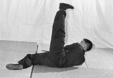 Posture 29 (planche 29) : le retournement vers la gauche au sol, les jambes croisées, le sabre suivant le corps