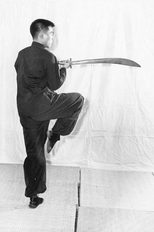 Posture 34 (planche 34) : le pied droit levé, le sabre retourné lame vers l&rsquo;extérieur, soutenu à son extrémité par la main