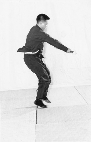 Posture 40 (planche 40) : le saut en arrière, le sabre passant à plat de l&rsquo;arrière vers l&rsquo;avant