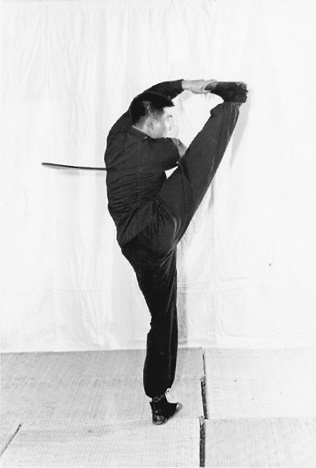 Posture 41 (planche 41) : la jambe droite levée à l&rsquo;horizontale, la pointe du pied saisie par la main gauche, le sabre rentré contre la taille