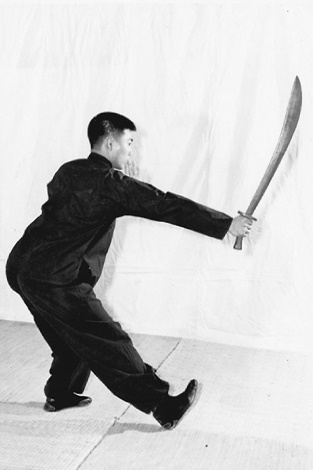 Posture 5 (planche 5) : le pas de la Grande Ourse à droite, le sabre abattu de l&rsquo;arrière vers l&rsquo;avant, le poignet droit venant frapper la paume gauche