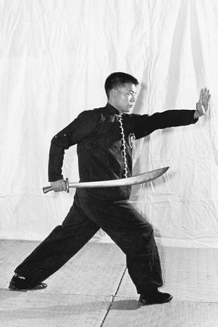 Posture 7 (planche 7) : la posture de l&rsquo;ascension à droite, le sabre tiré derrière le dos, la paume gauche à l&rsquo;intérieur de l&rsquo;épaule droite